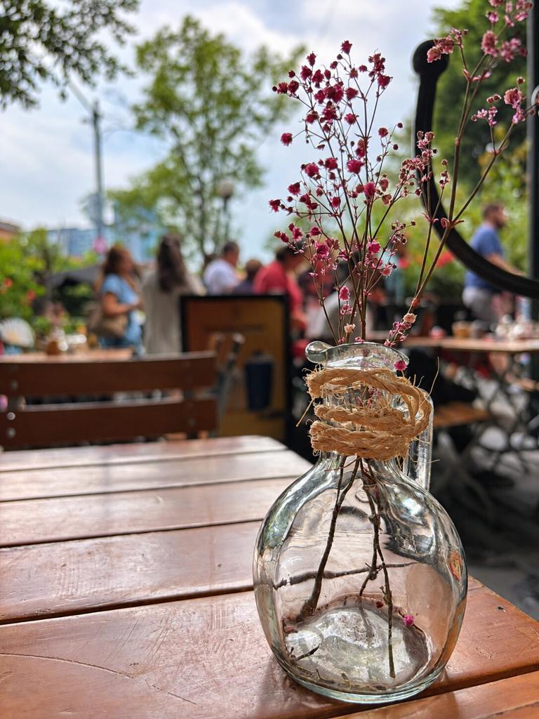 Fresh flowers in a glass vase on a wooden table